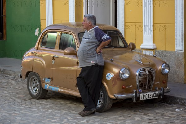 Proud car owner leaning against his small car, Trinidad, Cuba, Sancti Spíritus, Sancti Spíritus