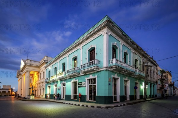 Turquoise residential building in the city centre of Santa Clara, Streetlife in the city centre of Santa Clara at the Parque de Santa Clara, Santa Clara, Cuba, Villa Clara
