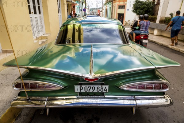Vintage car, historic road cruiser, green Impala, streetlife in the city centre of Santa Clara at the Parque de Santa Clara, Santa Clara, Cuba, Villa Clara