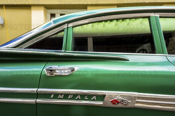 Vintage car, historic road cruiser, green Impala, streetlife in the city centre of Santa Clara at the Parque de Santa Clara, Santa Clara, Cuba, Villa Clara