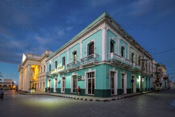 Turquoise residential building in the city centre of Santa Clara, Streetlife in the city centre of Santa Clara at the Parque de Santa Clara, Santa Clara, Cuba, Villa Clara