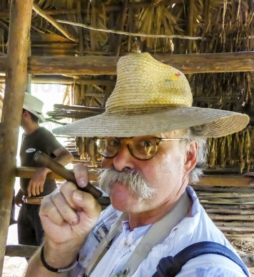 Hans Blossey Tourist smokes a Havana cigar, tobacco farm in the Vinalestal, Viñales, Cuba, Pinar del Río