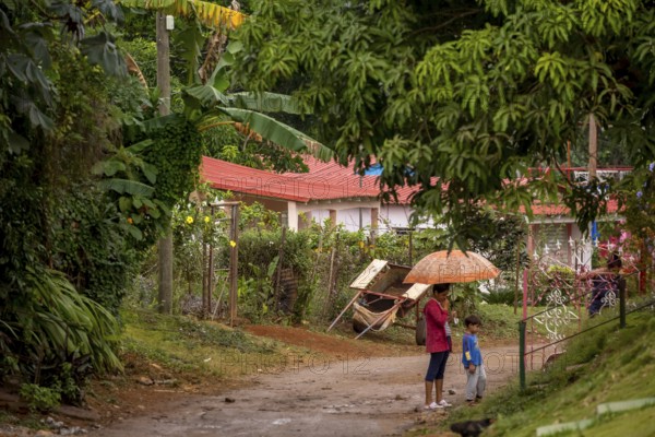 Street scene with woman and child and umbrella, Viñales, Cuba, Pinar del Río, Cuba, Viñales, Pinar del Río