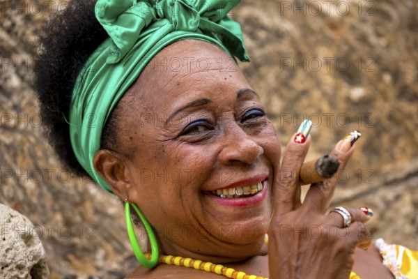 Old Cuban woman with green hair bow smokes a Havana cigar, Cuban woman with cigar and lacquered fingernails with the Cuban flag, Cuban flag, nail polish, La Habana, Cuba, Caribbean, Central America, Cuba, Europe, aerial view, birds-eyes view, aerial photography, aerial photography, overview, bird's eye view