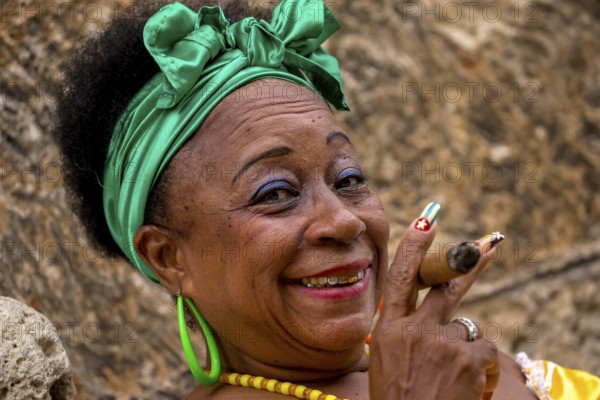 Old Cuban woman with green hair bow smokes a Havana cigar, Cuban woman with cigar and lacquered fingernails with the Cuban flag, Cuban flag, nail polish, La Habana, Cuba, Caribbean, Central America, Cuba, Europe, aerial view, birds-eyes view, aerial photography, aerial photography, overview, bird's eye view