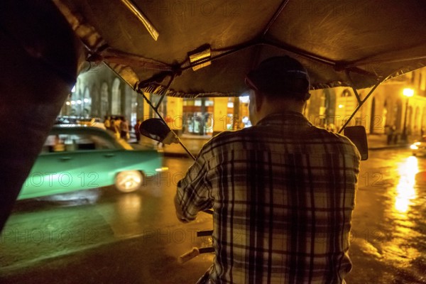 Rickshaw driver on a night ride through Havana, Havana, La Habana, Cuba, Cuba, Central America