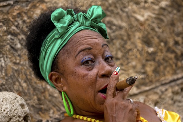 Old Cuban woman with green hair bow smokes a Havana cigar, Cuban woman with cigar and lacquered fingernails with the Cuban flag, Cuban flag, nail polish, La Habana, Cuba, Caribbean, Central America, Cuba, Europe, aerial view, birds-eyes view, aerial photography, aerial photography, overview, bird's eye view