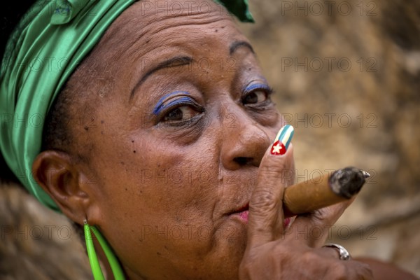 Old Cuban woman with green hair bow smokes a Havana cigar, Cuban woman with cigar and lacquered fingernails with the Cuban flag, Cuban flag, nail polish, La Habana, Cuba, Caribbean, Central America, Cuba, Europe, aerial view, birds-eyes view, aerial photography, aerial photography, overview, bird's eye view
