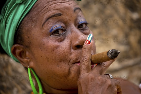 Old Cuban woman with green hair bow smokes a Havana cigar, Cuban woman with cigar and lacquered fingernails with the Cuban flag, Cuban flag, nail polish, La Habana, Cuba, Caribbean, Central America, Cuba, Europe, aerial view, birds-eyes view, aerial photography, aerial photography, overview, bird's eye view