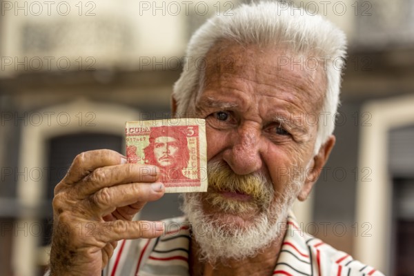 Old Cuban man holding a three peso banknote with the portrait of Ernesto Che Guevara in his hand, local currency, CUP, Cuban Peso, poverty, La Habana, Havana, Cuba, Cuba, Europe, aerial view, birds-eyes view, aerial photography, aerial photography, overview, bird's eye view