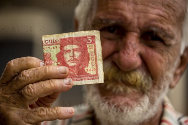 Old Cuban man holding a three peso banknote with the portrait of Ernesto Che Guevara in his hand, local currency, CUP, Cuban Peso, poverty, La Habana, Havana, Cuba, Cuba, Europe, aerial view, birds-eyes view, aerial photography, aerial photography, overview, bird's eye view