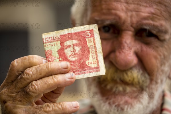 Old Cuban man holding a three peso banknote with the portrait of Ernesto Che Guevara in his hand, local currency, CUP, Cuban Peso, poverty, La Habana, Havana, Cuba, Cuba, Europe, aerial view, birds-eyes view, aerial photography, aerial photography, overview, bird's eye view