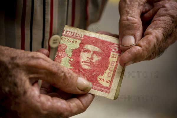 Old Cuban man holding a three peso banknote with the portrait of Ernesto Che Guevara in his hand, local currency, CUP, Cuban Peso, poverty, La Habana, Havana, Cuba, Cuba, Europe, aerial view, birds-eyes view, aerial photography, aerial photography, overview, bird's eye view
