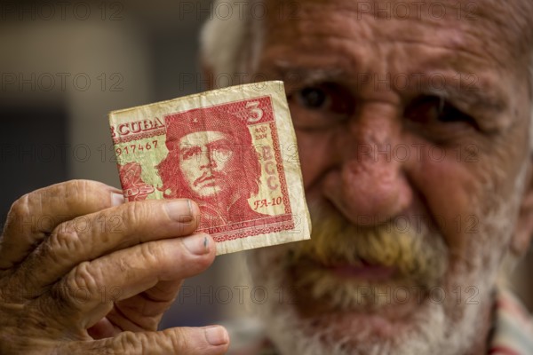 Old Cuban man holding a three peso banknote with the portrait of Ernesto Che Guevara in his hand, local currency, CUP, Cuban Peso, poverty, La Habana, Havana, Cuba, Cuba, Europe, aerial view, birds-eyes view, aerial photography, aerial photography, overview, bird's eye view