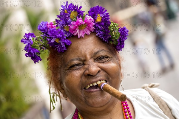 Old Cuban woman with flowers and cigar posing for a tip for tourists, La Habana, Havana, Cuba, Cuba, Europe, aerial photo, birds-eyes view, aerial photography, aerial photography, overview, bird's eye view