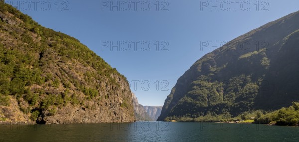 Fjord, Nærøyfjord, rock faces, mountains, blue sky, Styvi, Sogn og Fjordane, Norway, Scandinavia, Europe, NOR, travel, tourism, destination, sightseeing, sea voyage, Hurtigruten, Hurtigruten trip, tourism, Norwegian, Scandinavian, tourist, cruise, adventure trip, waters, water, shipping, seafaring, sightseeing, hills, trees, forests, sky