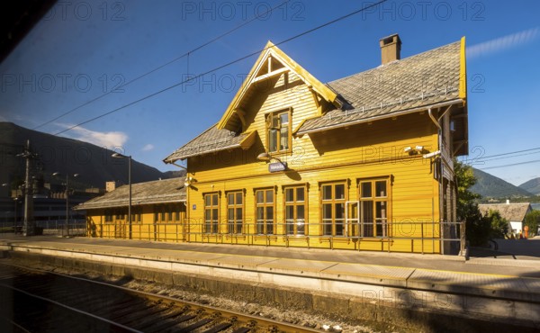 Yellow wooden railway station building Vaksdal, railway tracks, blue sky, near Bergen city railway station, Hordaland, Norway, Scandinavia, Europe, Bergen, NOR, travel, tourism, destination, sightseeing, sea voyage, Hurtigruten, Hurtigruten trip, tourism, Norwegian, Scandinavian, tourist, cruise, adventure trip, house, building, roof