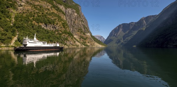 Excursion ship on a fjord, Flåm, Gudvangen, rock walls, trees, blue sky, Sogn og Fjordane, Norway, Scandinavia, Europe, NOR, travel, tourism, destination, sightseeing, sea voyage, Hurtigruten, Hurtigruten trip, tourism, Norwegian, Scandinavian, tourist, cruise, adventure trip, mountains, tourist trip, shipping, river, stones, tourist ship, water, waters