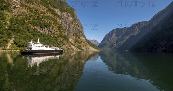 Excursion ship on a fjord, Flåm, Gudvangen, rock walls, trees, blue sky, Sogn og Fjordane, Norway, Scandinavia, Europe, NOR, travel, tourism, destination, sightseeing, sea voyage, Hurtigruten, Hurtigruten trip, tourism, Norwegian, Scandinavian, tourist, cruise, adventure trip, mountains, tourist trip, shipping, river, stones, tourist ship, water, waters
