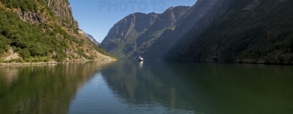 Excursion ship on a fjord, Flåm, Gudvangen, rock walls, trees, blue sky, Sogn og Fjordane, Norway, Scandinavia, Europe, NOR, travel, tourism, destination, sightseeing, sea voyage, Hurtigruten, Hurtigruten trip, tourism, Norwegian, Scandinavian, tourist, cruise, adventure trip, mountains, tourist trip, shipping, river, stones, tourist ship, water, waters