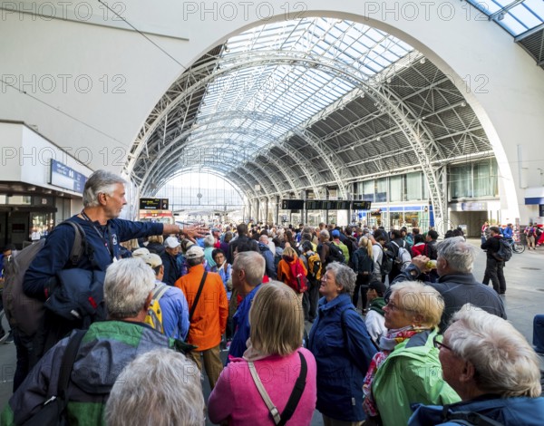 Tourists at Bergen railway station, tour guide, glass dome roof, train, Bergen, Hordaland, Norway, Scandinavia, Europe, NOR, travel, tourism, destination, sightseeing, sea voyage, Hurtigruten, Hurtigruten trip, tourism, Norwegian, Scandinavian, tourist, cruise, adventure trip, train journey, people, hall, station hall, railway, information boards, passenger transport, local passenger transport, crowds, tourist crowds
