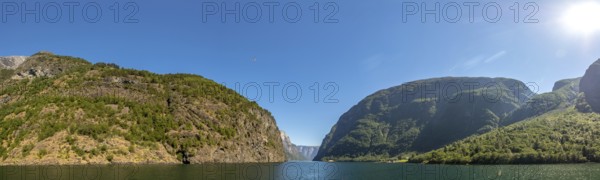 Fjord, Nærøyfjord, rock faces, mountains, blue sky, sunshine, Styvi, Sogn og Fjordane, Norway, Scandinavia, Europe, NOR, travel, tourism, destination, sightseeing, sea voyage, Hurtigruten, Hurtigruten trip, tourism, Norwegian, Scandinavian, tourist, cruise, adventure trip, waters, water, shipping, seafaring, sightseeing, hills, trees, forests, sky