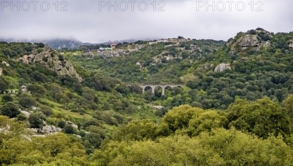 Sardinia, rugged granite mountains of Gallura, quarries and viaduct in hilly landscape, Olbia, Europe, Province of Sassari, Italy, architecture, view, mountains, trees, elevation, exploration, rocks, rock formation, Gallura, geography, granite mountains, hills, hilly landscape, engineering, landscape, nature, panorama, travel, sightseeing, summer, quarries, structure, scenery, day, tourism, tourist destination, environment, viaduct, destination, geological formations, industrial, rural, Mediterranean, natural, vegetation
