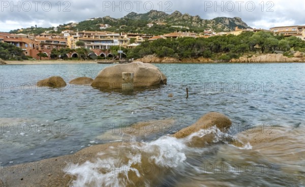 Sardinia, waves on the rocky coast, residential complex in the picturesque harbour town of Porto Cervo and bay, Arzachena, Europe, Province of Sassari, Italy, architecture, boats, bay, recreation, rocks, distant view, leisure, building, harbour, harbour town, sky, island scene, coast, coastline, landscape, marina, sea, Mediterranean, nature, panorama, Porto Cervo, travel, sailing boats, sightseeing, summer, town, rocky coast, daylight, tourism, shore, holiday region, water, waves, residential complex, yacht club, charming, picturesque, Mediterranean