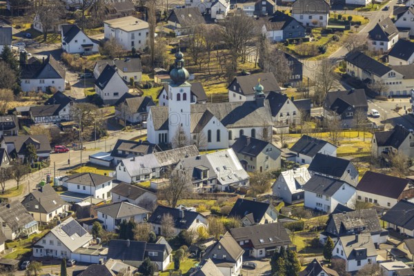 Aerial view, residential area and Roman Catholic parish church St. Kunibertus in the town centre, Hünsborn, Wenden, Sauerland, North Rhine-Westphalia, Germany, place of worship, DE, monument protection, Europe, religious community, place of worship, property tax, holy site, real estate, church, parish, denomination, aerial view, aerial photography, aerial photography, religion, religious site, overview, bird's-eye view, residential area, living and life, residential area, residential quality, residential quarter, housing estate, residential district, birds-eyes view, overview