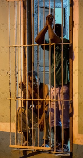 Paid car guards behind their barred windows in the old town of Trinidad, Street scene in the old town of Trinidad, Trinidad, Cuba, Sancti Spíritus, Cuba, Sancti Spíritus