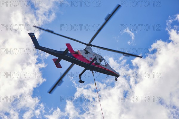 Helicopter flying high in the sky on a clear day, transport helicopter, timber transport, Saas Grund, Canton Valais, Switzerland