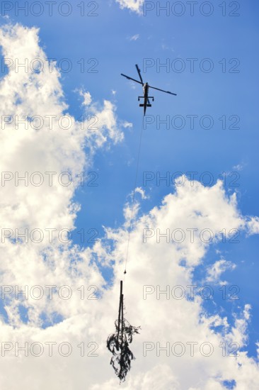 Helicopter lifts tree in cloudy sky, transport helicopter, timber transport, Saas Grund, Canton Valais, Switzerland
