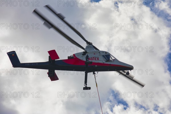 Aerial view of a helicopter with clouds in the background, transport helicopter, timber transport, Saas Grund, Canton Valais, Switzerland