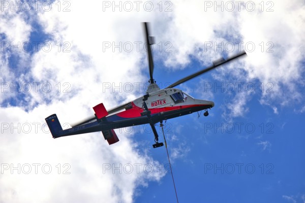 Helicopter moving in the cloudy sky, transport helicopter, timber transport, Saas Grund, Canton Valais, Switzerland