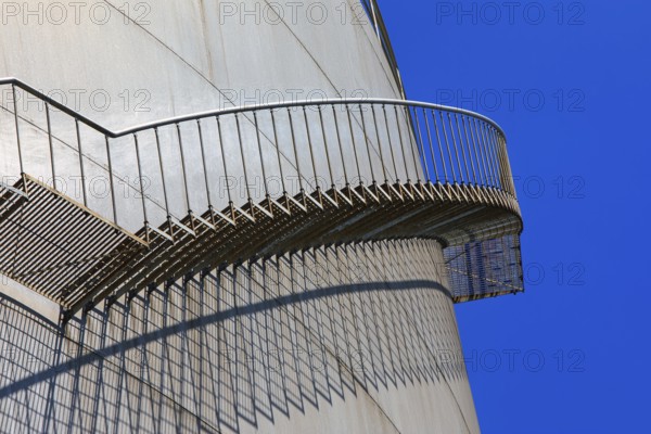 Metal staircase with striking shadow play on the side of a large tank, elevated tank, chemical, company, Grenzach- Wyhlen, Baden-Württemberg, Germany