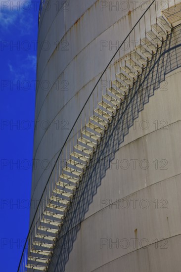 Metal staircase on a large industrial gas tank under a clear blue sky, elevated tank, chemical, company, Grenzach- Wyhlen, Baden-Württemberg, Germany