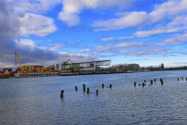 Industrial harbour with containers and cranes under a cloudy blue sky on a river, Rhine, Birsfelden harbour, Canton Baselland, Switzerland