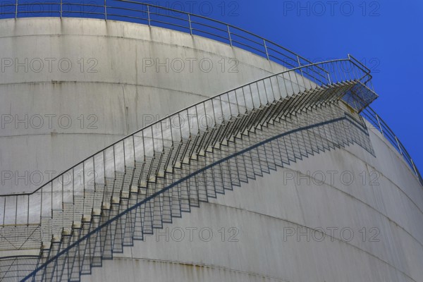 Large, curved metal staircase runs along a tank under a clear sky, elevated tank, chemical, company, Grenzach- Wyhlen, Baden-Württemberg, Germany