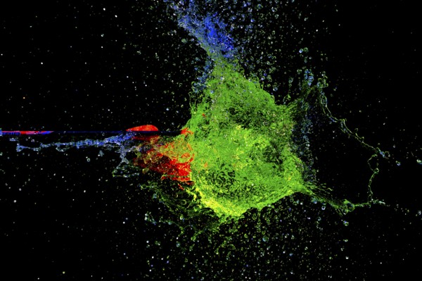 A vivid, explosive clash of green and red as an arrow pierces a water balloon, high-speed shot, water balloon, arrow