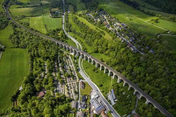 Aerial view, Altenbekener Viaduct, Adenauerstraße, railway viaduct Bridge structure, also called Bekeviaduct or Great Viaduct, suburban railway, Altenbeken cemetery and cross chapel on the road Alter Kirchweg, residential area Am Stapelsberg, meadows and fields, Altenbeken, East Westphalia, North Rhine-Westphalia, Germany, railway viaduct, bridge structure, Beke Viaduct, Great Viaduct, Altenbeken cemetery, Kreuzkapelle, Alter Kirchweg, residential area, Am Stapelsberg, meadows, fields, landscape, architecture, traffic, rail transport, railway, infrastructure, building, history, historical, rural, nature, living, green spaces, village, town, perspective, sky, outdoor area