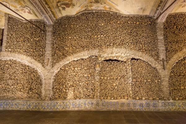 Piled bones in the ossuary, Capela dos ossos parede, chapel of bones, bone chapel, ossuary in Évora, Evora, district of Évora, Portugal