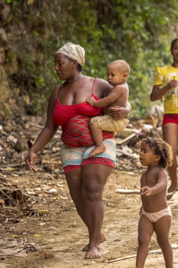 Mother with two children barefoot at a rubbish dump, poverty on the island of Cuba, Trinidad, Cuba, Sancti Spíritus, Cuba
