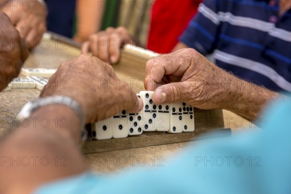 Old Cubans playing dominoes at a table on the street in the city centre of Trinidad, Trinidad, Cuba, Sancti Spíritus, Cuba, Sancti Spíritus