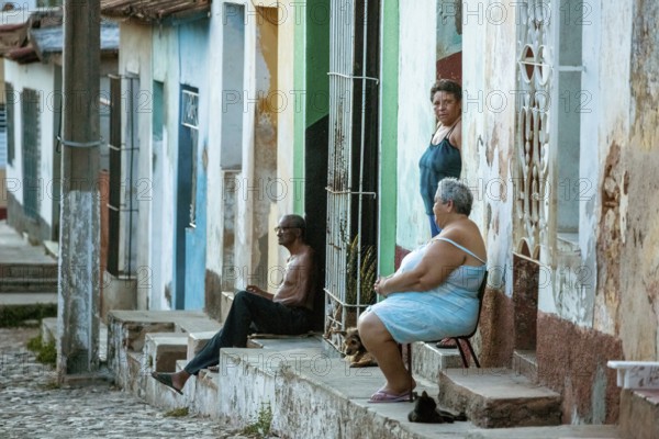 Cubans sitting on their steps in front of their houses in the old town, Street scene in the old town of Trinidad, Trinidad, Cuba, Sancti Spíritus, Cuba, Sancti Spíritus