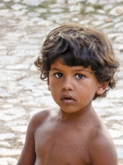 Little Cuban boy on the street in front of an old wall, street scene in the old town of Trinidad, Trinidad, Cuba, Sancti Spíritus, Cuba