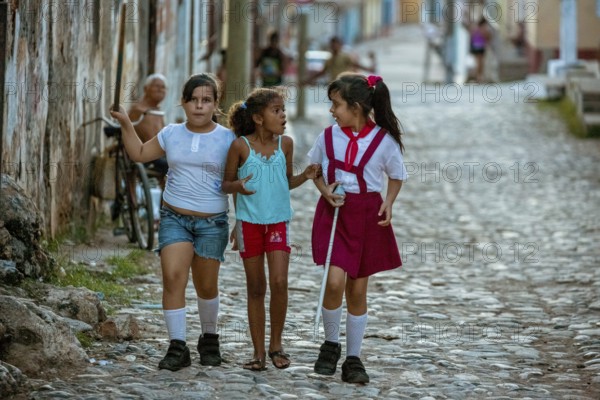 Three girls discussing on the street, Schoolgirls, Children, Street scene in the old town of Trinidad, Trinidad, Cuba, Sancti Spíritus, Cuba, Sancti Spíritus