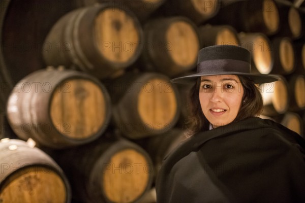 Classic travel guide with student robe, zorro hat and cape, port wine barrels, wine cellar of the Sandemann winery in Gaia, Porto, Vila Nova de Gaia, Porto district, Portugal, Europe, aerial view, birds-eyes view, Travel, travel photography