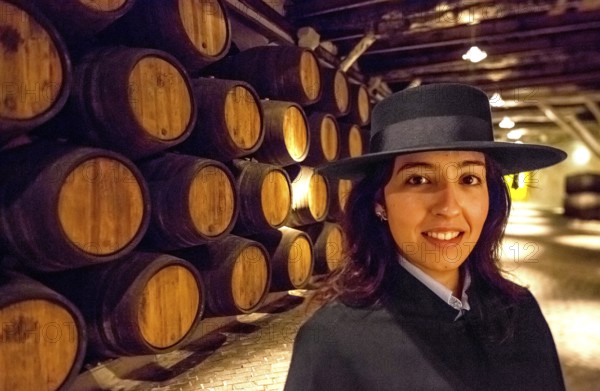 Classic travel guide with student robe, zorro hat and cape, port wine barrels, wine cellar of the Sandemann winery in Gaia, Porto, Vila Nova de Gaia, Porto district, Portugal, Europe, aerial view, birds-eyes view, Travel, travel photography