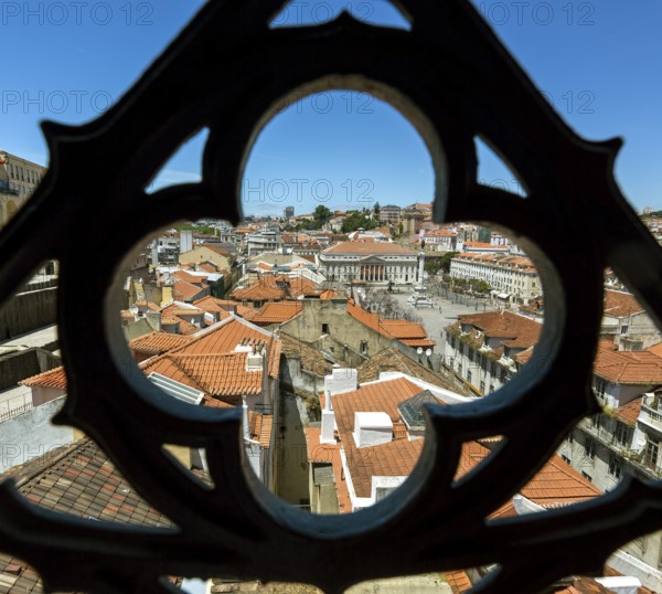View through wrought iron grating from Portugal's most famous lift Elevador do Município or Elevador da Biblioteca and Elevador de S. Julião to the old town of Portugal with the red roofs, Lisbon, District of Lisbon, Portugal