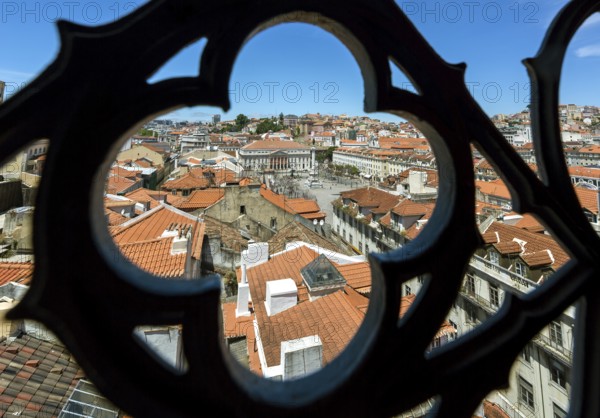 View through wrought iron grating from Portugal's most famous lift Elevador do Município or Elevador da Biblioteca and Elevador de S. Julião to the old town of Portugal with the red roofs, Lisbon, District of Lisbon, Portugal
